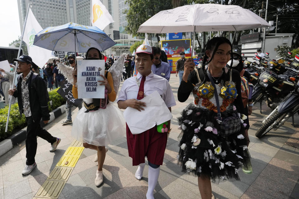 Environmental activists hold up posters read " we are worried about the climate crisis " during a protest calling for the government to take immediate action against climate change in Jakarta, Indonesia, Friday, Sept. 23, 2022. (AP Photo/Achmad Ibrahim)