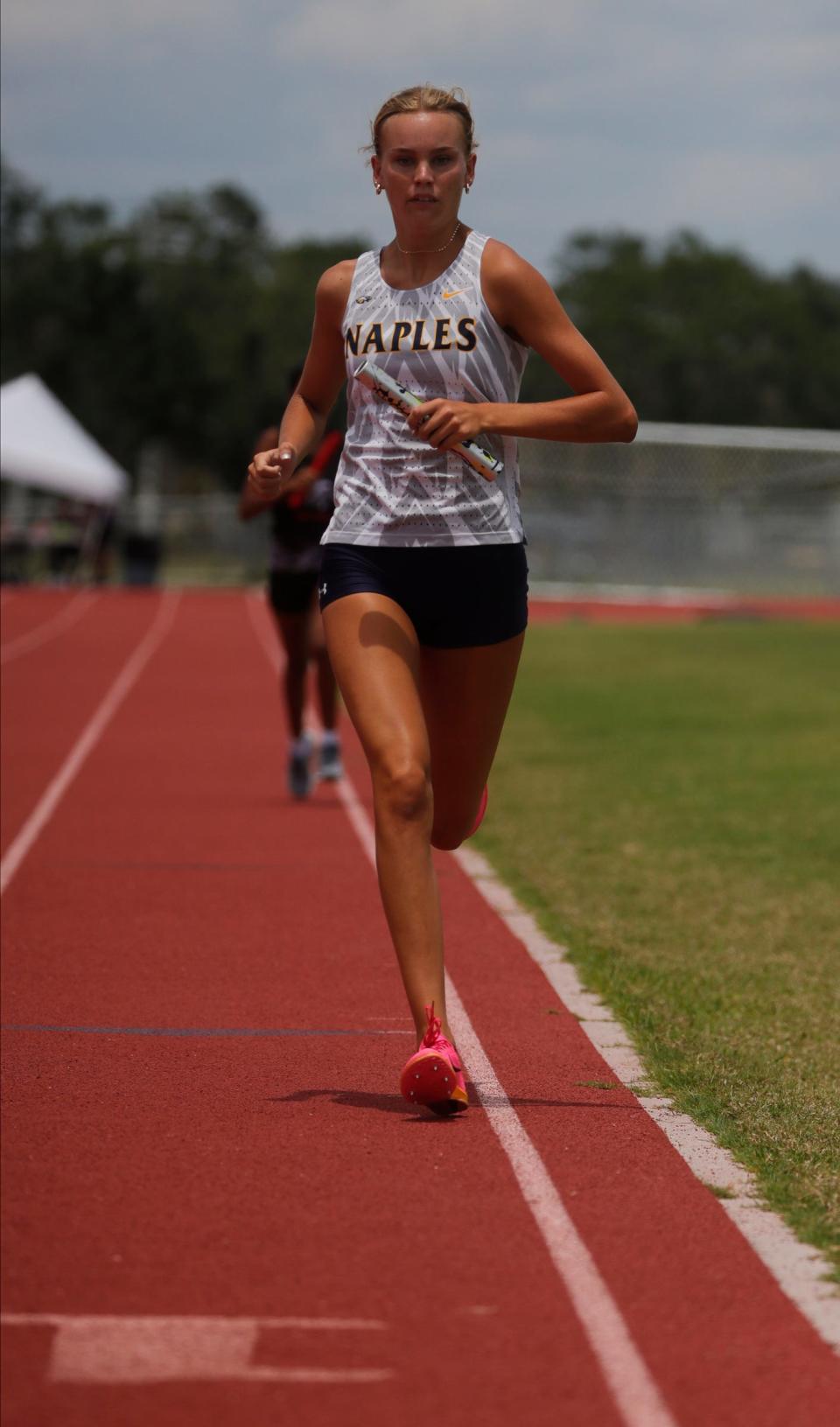 Naples High School runner Tara Watkins reaches the finish line in first place during the 4x800 relay race. The District 3A-12 track meet was hosted at Cypress Lake High School Wednesday, April 26, 2023. Schools participating included: Barron Collier, Bonita Springs, Cypress Lake, East Lee, Golden Gate, Immokalee, Naples and South Fort Myers.