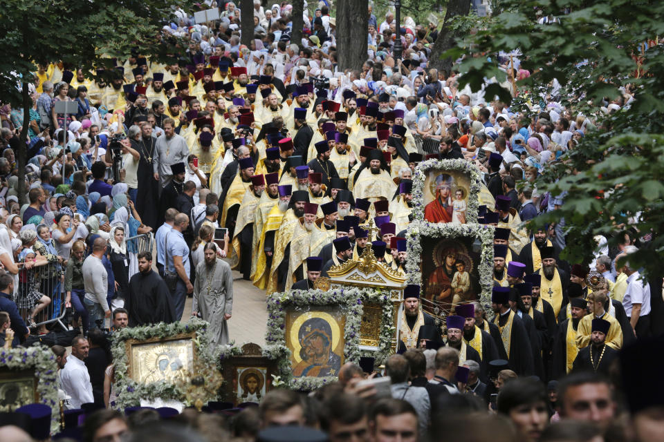 FILE - In this July 27, 2017 file photo, orthodox believers and clergymen march to prayer in Kiev, Ukraine, Thursday, July 27, 2017, in observance of the holiday marking the adoption of Christianity by what is now Russia and Ukraine in the 10th century. Tensions over the imminent formation of a Ukrainian Orthodox church independent of Moscow are raising fears that nationalists may try to seize Russian church properties. (AP Photo/Efrem Lukatsky)