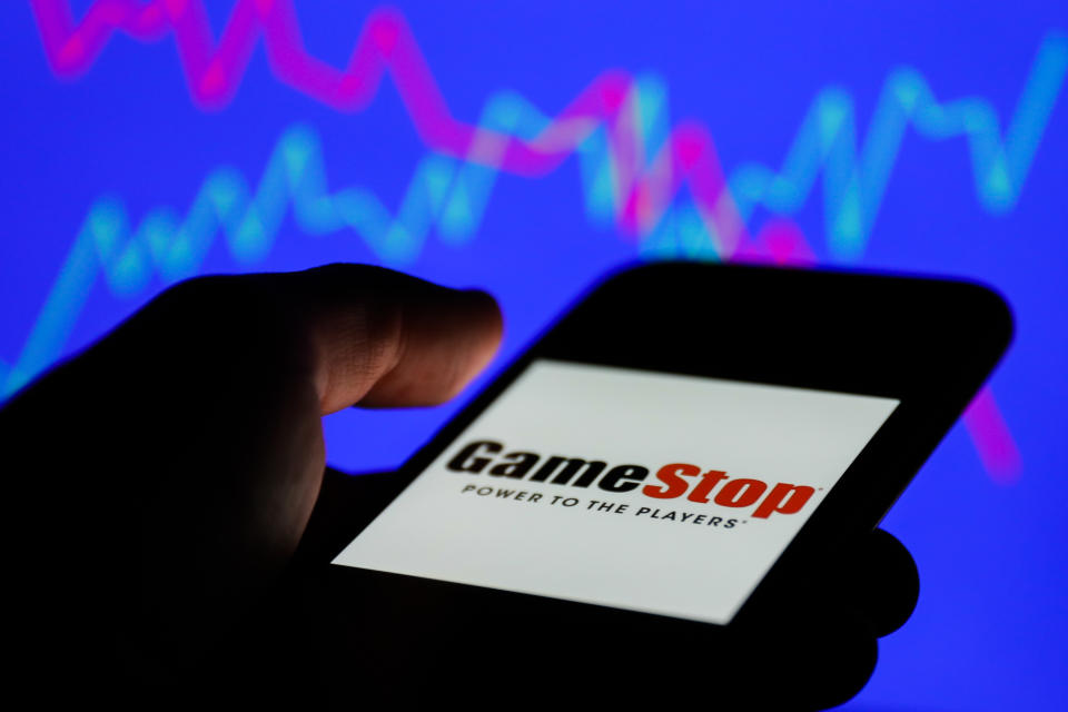 GameStop logo displayed on a phone screen and a illustrative stock chart on the background are seen in this illustration photo taken in Poland on January 31, 2021. (Photo Illustration by Jakub Porzycki/NurPhoto via Getty Images)