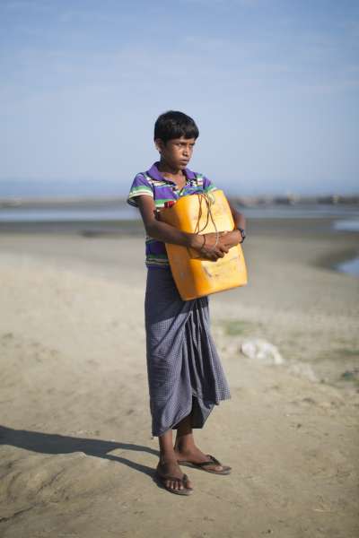 11月3日，13歲的羅興亞難民納比靠著一只黃色塑膠油桶渡過納夫河，從緬甸逃到孟加拉（AP）