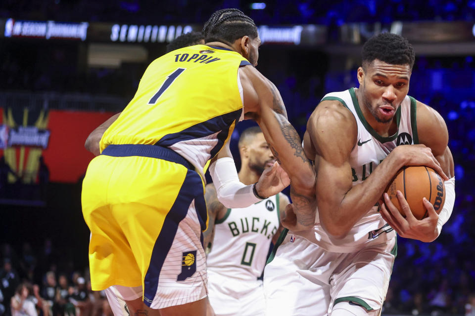 Milwaukee Bucks forward Giannis Antetokounmpo (34) secures a rebound next to Indiana Pacers forward Obi Toppin (1) during the second half of a semifinal in the NBA basketball In-Season Tournament, Thursday, Dec. 7, 2023, in Las Vegas. (AP Photo/Ian Maule)