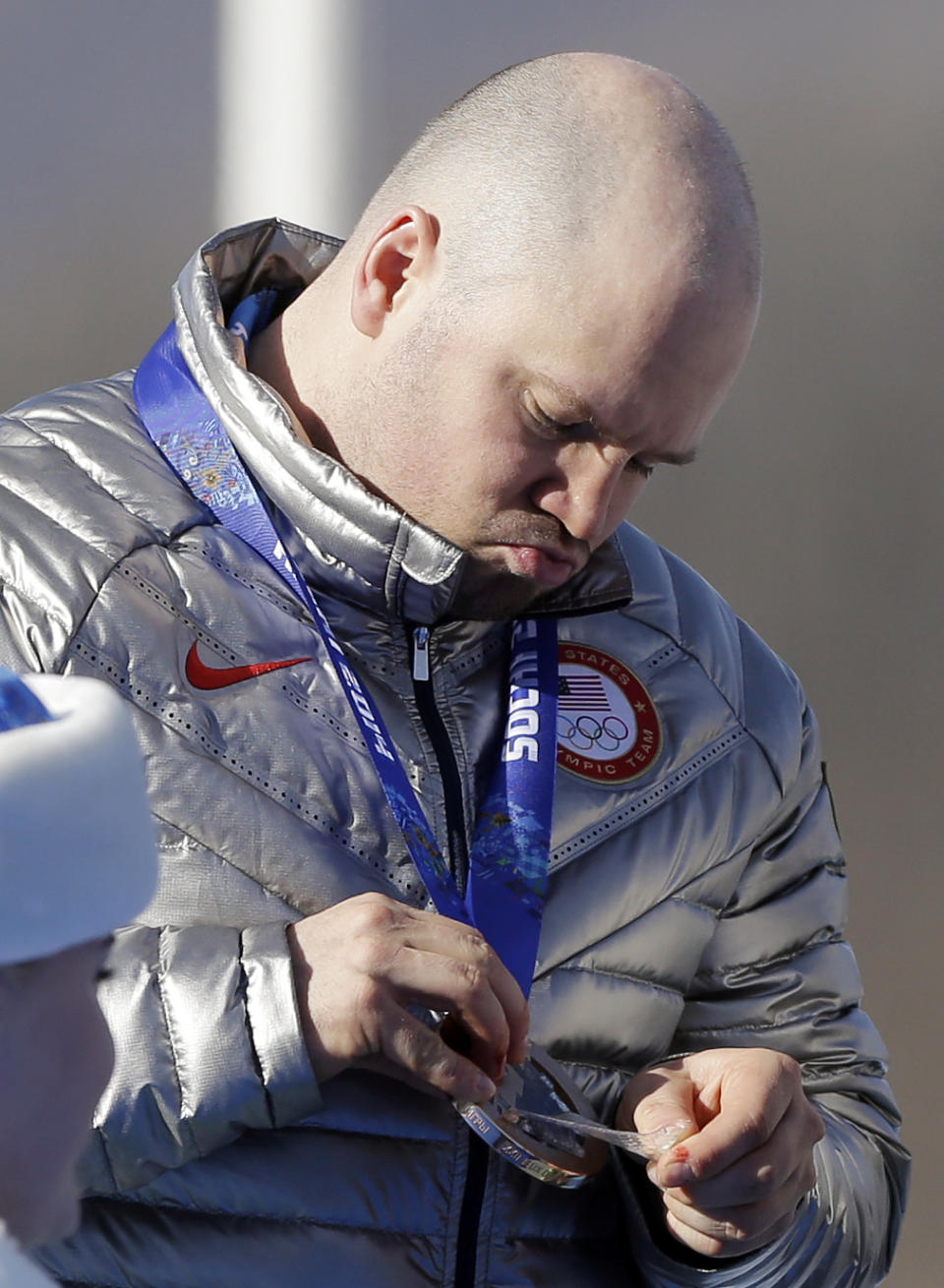 The team driver of United States USA-1, Steven Holcomb, looks at his bronze medal after the men's four-man bobsled competition final at the 2014 Winter Olympics, Sunday, Feb. 23, 2014, in Krasnaya Polyana, Russia. (AP Photo/Natacha Pisarenko)