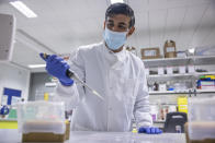 Britian's Chancellor of the Exchequer Rishi Sunak gestures, during a visit to Imperial Clinic Research Facility at Hammersmith Hospital, where he met staff and was instructed on research techniques, to mark the announcement of his Spending Review, in London, Wednesday, Nov. 25, 2020. (Jack Hill/Pool Photo via AP)