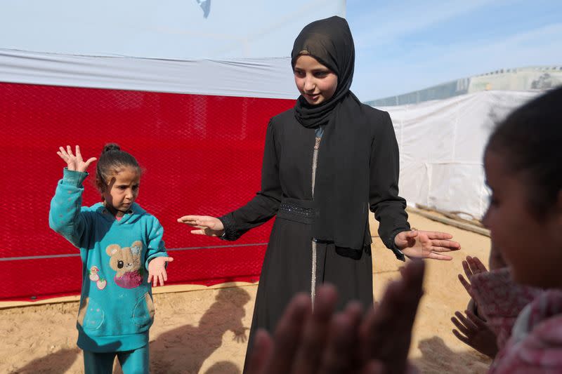 Raghad Abu Nadi, a displaced Palestinian girl whose father was killed in Israeli fire, plays with children outside her family makeshift shelter, in Rafah in the southern Gaza Strip