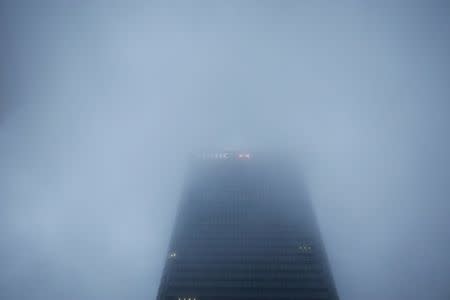 The logo on the building of HSBC's London headquarters appears through the early morning mist in London's Canary Wharf financial district, Britain March 28, 2017. REUTERS/Russell Boyce