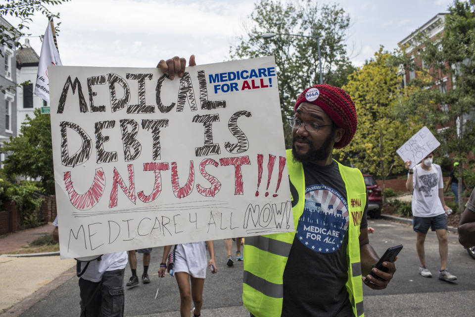 A man holding a medical debt sign gathers near the Capitol as he takes part in the March for Medicare for All in Washington D.C. on July 24, 2021. (Photo by Probal Rashid/LightRocket via Getty Images)