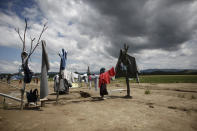 <p>A refugee woman hangs clothes to dry at the sun after heavy rainfall at a makeshift camp for migrants and refugees at the Greek-Macedonian border near the village of Idomeni, Greece, May 22, 2016. (Kostas Tsironis/REUTERS) </p>