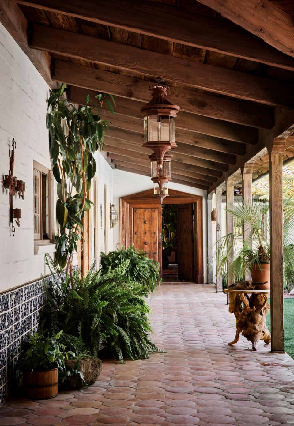 Saltillo tile floors extend from the exterior of the home to the interior. The pool is situated in the courtyard to the right.