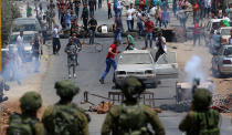 <p>Israeli soldiers fire tear gas during clashes with Palestinian protesters after a protest in support of Palestinian prisoners on hunger strike in Israeli jails, in the West Bank village of Beita, near Nablus, May 18, 2017. According to media sources, a Palestinian was allegedly shot dead by an Israeli settler during clashes at Huwwara village near the city of Nablus. (Photo: Alaa Badarneh/EPA) </p>