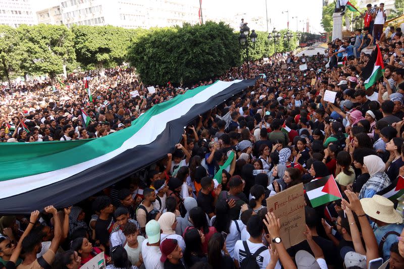 Varias personas sostienen banderas durante una protesta propalestina tras la muerte de cientos de palestinos en una explosión en el hospital Al-Ahli de Gaza, de la que se culparon mutuamente las autoridades israelíes y palestinas, en Túnez