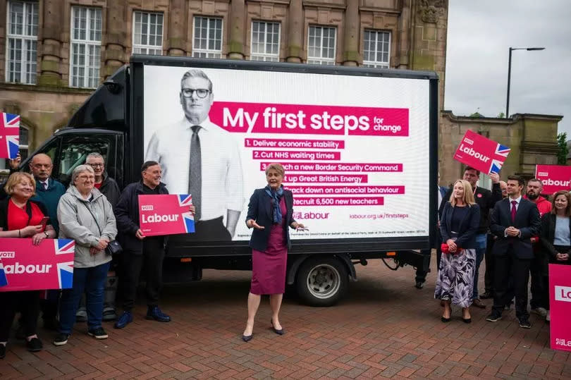 Labour's Shadow Home Secretary Yvette Cooper meets party supporters next to a digital bill board featuring the six election pledges of Labour Leader Keir Starmer in Leigh