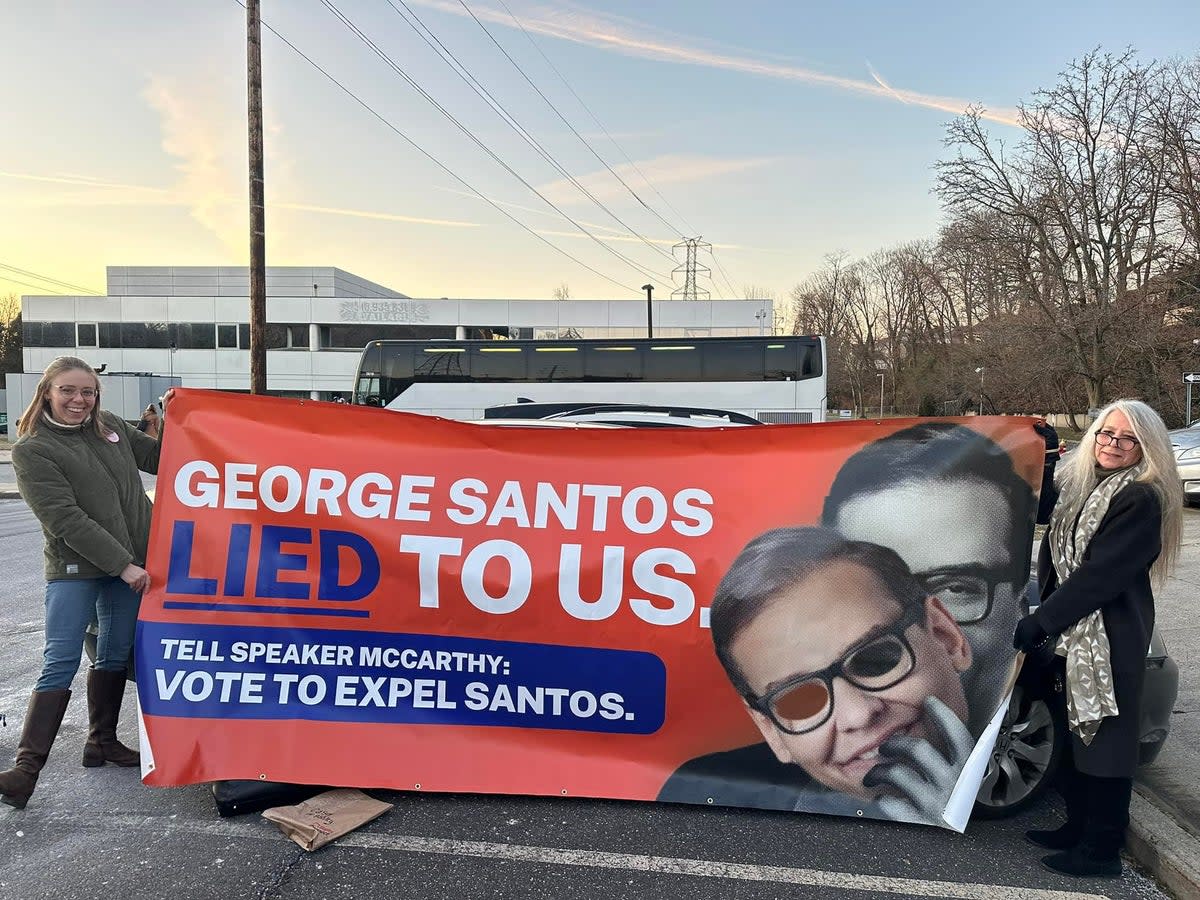 Members of the ‘Concerned Citizens of NY-03’ group reveal a banner slamming George Santos (Concerned Citizens of NY-03)