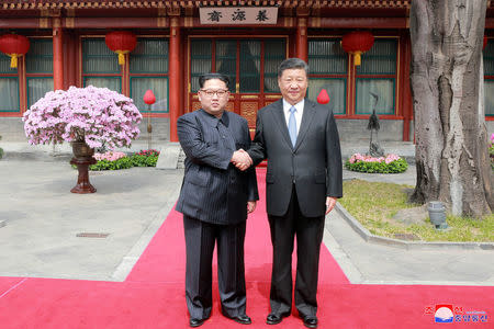 North Korean leader Kim Jong Un shakes hands with Chinese President Xi Jinping, as he paid an unofficial visit to Beijing, China, in this undated photo released by North Korea's Korean Central News Agency (KCNA) in Pyongyang March 28,2018. KCNA/via Reuters