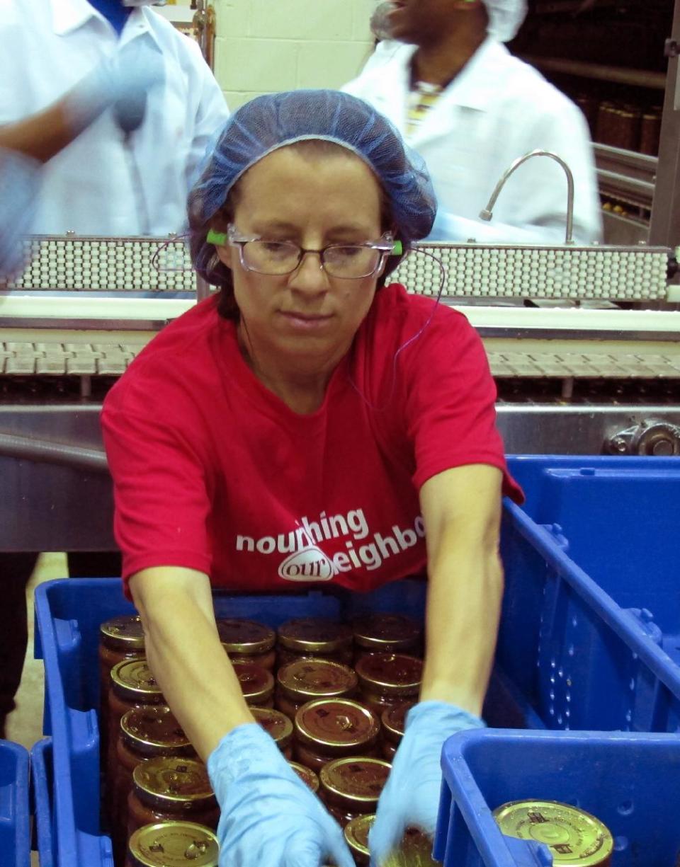 A Campbell Soup Co. worker puts jars of Just Peachy Salsa into a bin at the Campbell Soup Co. headquarters in Camden, N.J., on Wednesday, Aug. 1, 2012. Campbell and other firms are donating ingredients, materials and manufacturing for the salsa, which is being sold by the Food Bank of South Jersey. (AP Photo/Geoff Mulvihill)