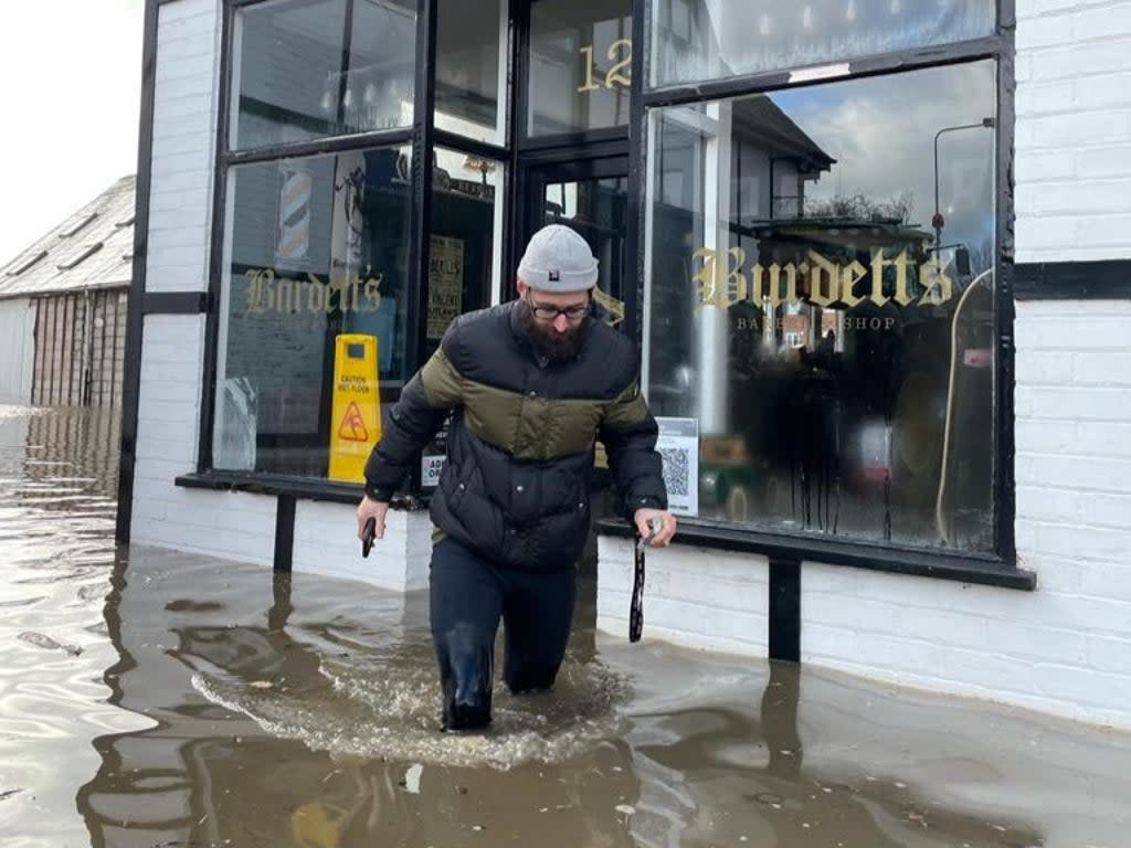 Brent Nile outside his barber shop during the flooding (Supplied)