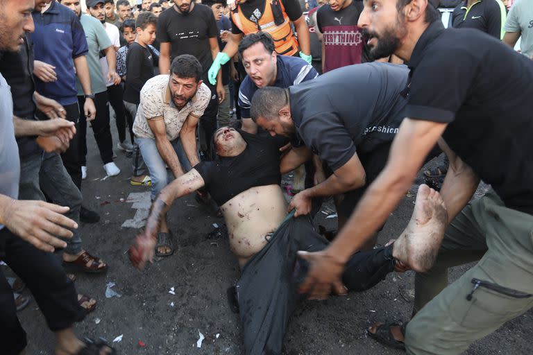 n palestino herido es transportado desde tierra tras un ataque aéreo israelí frente a la entrada del hospital al-Shifa en la ciudad de Gaza, (AP Photo/Abed Khaled)