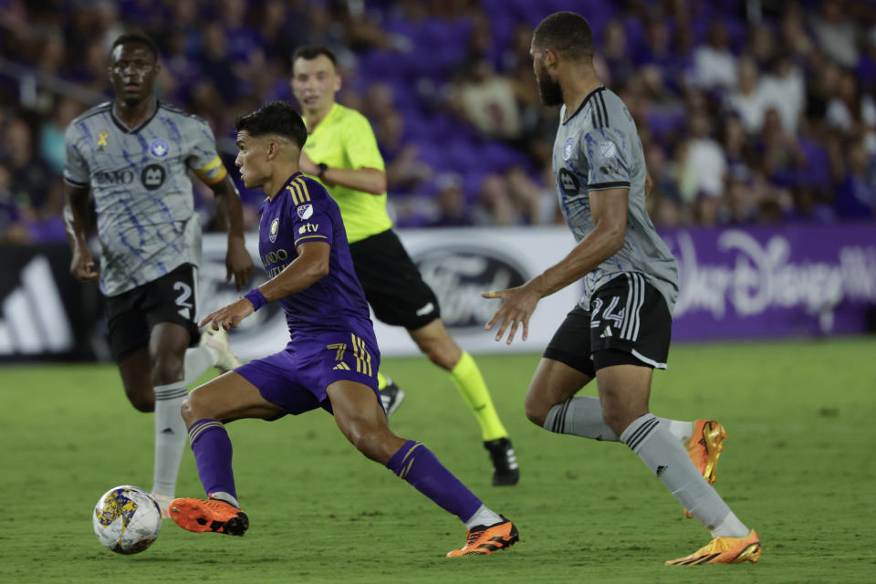 Orlando City forward Ramiro Enrique, front left, brings ball downfield past CF Montreal defender George Campbell, right, during the second half of an MLS soccer match, Saturday, Sept. 30, 2023, in Orlando, Fla. (AP Photo/Kevin Kolczynski)