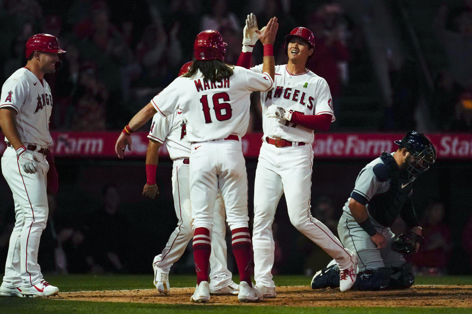 Los Angeles Angels designated hitter Shohei Ohtani, right, celebrates with Brandon Marsh (16), Mike Trout, left, and Andrew Velazquez after hitting a grand slam home run during the seventh inning of a baseball game against the Tampa Bay Rays in Anaheim, Calif., Monday, May 9, 2022. Andrew Velazquez, Brandon Marsh, and Mike Trout also scored. (AP Photo/Ashley Landis)