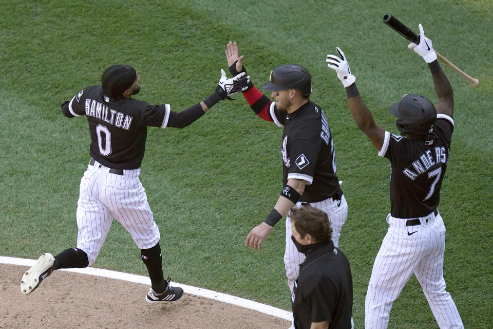 Chicago White Sox's Billy Hamilton, left, Yasmani Grandal, center and Tim Anderson celebrate after Hamilton and Grandal scored on an RBI-double by Leury Garcia during the fourth inning of a baseball game against the Cleveland Indians, Saturday, May 1, 2021, in Chicago. (AP Photo/Charles Rex Arbogast)