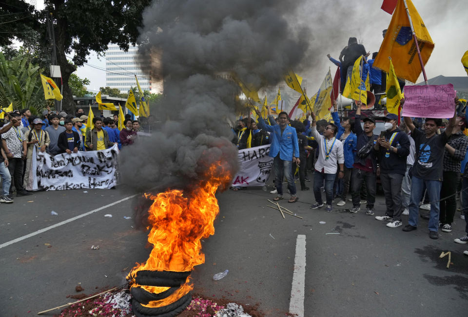 Student activists burn tyres during a rally against fuel price hikes in Jakarta, Indonesia, Monday, Sept. 5, 2022. Fuel prices increased by about 30 percent across Indonesia on Saturday after the government reduced some of the costly subsidies that have kept inflation in Southeast Asia's largest economy among the world's lowest. (AP Photo/Tatan Syuflana)