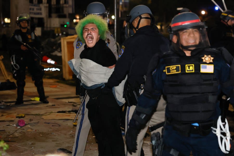 Police make an arrest as they face-off with pro-Palestinian students after destroying part of the encampment barricade on the campus of the University of California, Los Angeles (UCLA) in Los Angeles, California, early on May 2, 2024. (Photo by ETIENNE LAURENT/AFP via Getty Images)