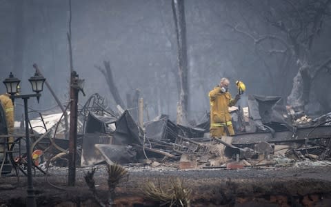 Firefighters search a burned-out building in Paradise, California - Credit: David Paul Morris/Bloomber