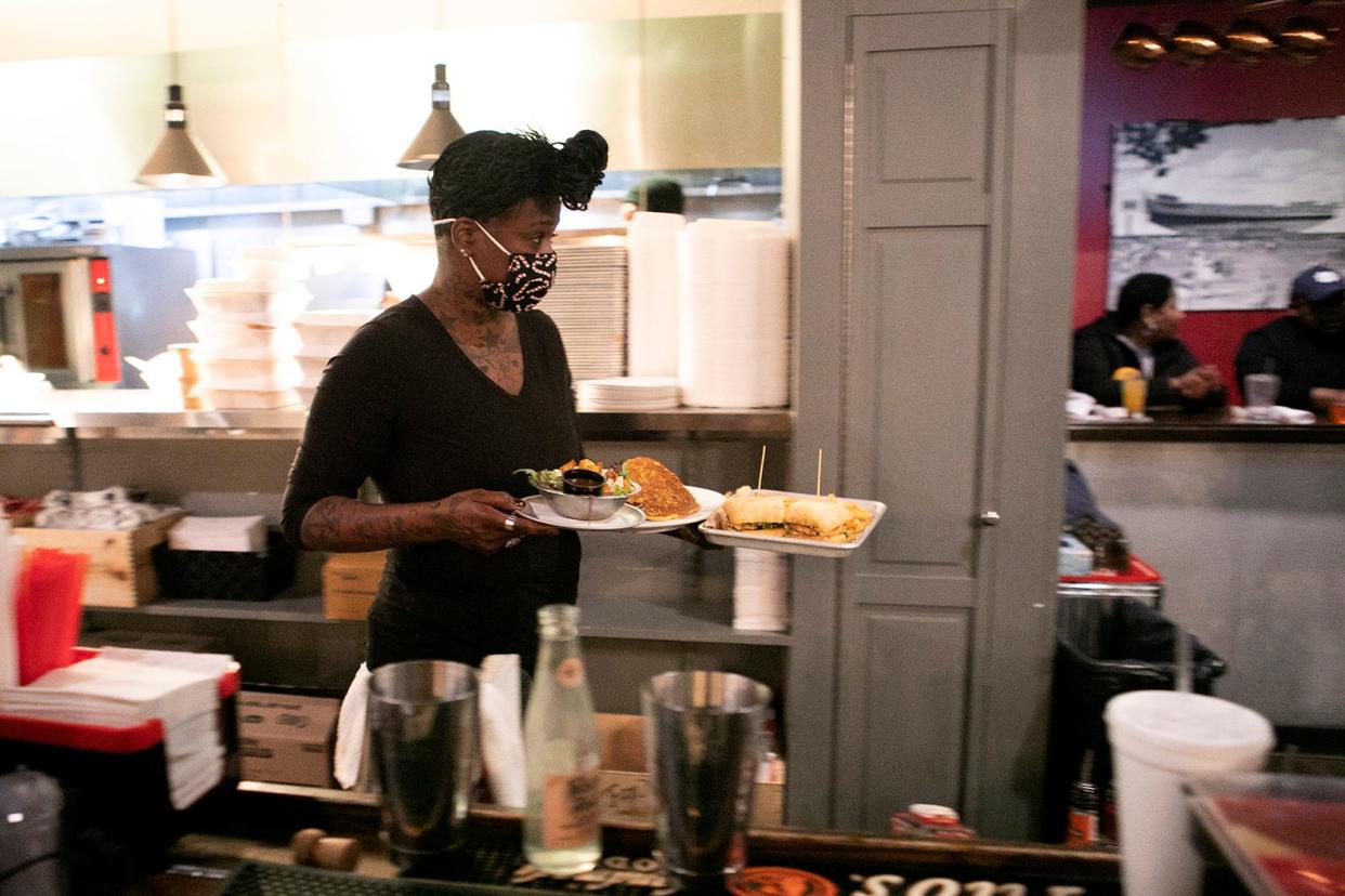 Bartender Tamara Broady steps away to carry a food order at Pat and Gracie's on Gay Street on Nov. 12. Restaurants and bars have been among the businesses struggling the most to find workers to meet demand. There were more than 300,000 online postings for work in Ohio  from mid-September to mid-October.