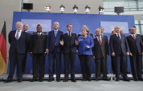 French President Emmanuel Macron, center left, speaks with German Chancellor Angela Merkel, center right, during a group photo at a conference on Libya at the chancellery in Berlin, Germany, Sunday, Jan. 19, 2020. German Chancellor Angela Merkel hosts the one-day conference of world powers on Sunday seeking to curb foreign military interference, solidify a cease-fire and help relaunch a political process to stop the chaos in the North African nation. (AP Photo/Michael Sohn)