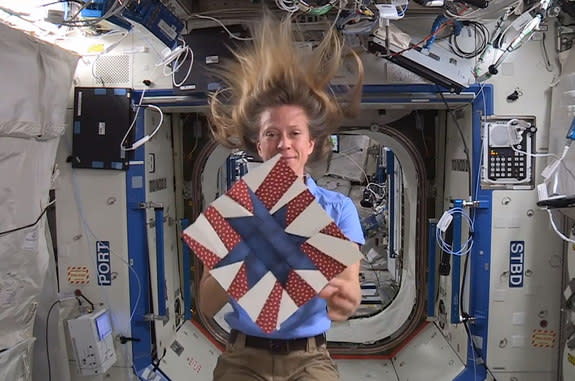 NASA astronaut Karen Nyberg displays the star-theme quilt block she created aboard the International Space Station.