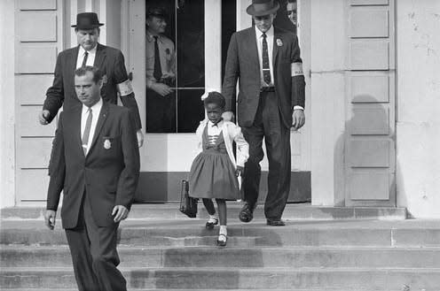 US deputy marshals escort 6-year-old Ruby Bridges outside William Frantz Public School in New Orleans in 1960. [AP Photo]