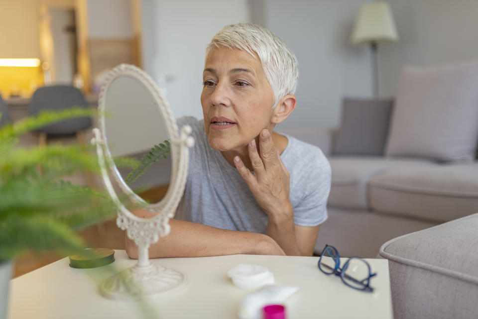 mature woman looking at skin 