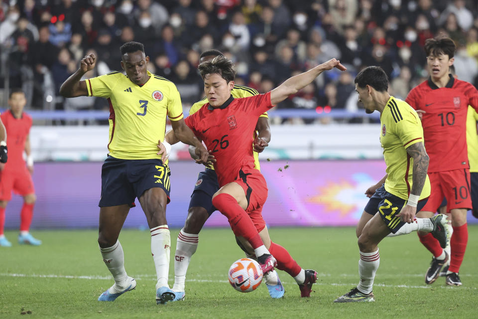 South Korea's Oh Hyeon-gyu, center, fights for the ball against Colombia's Jhon Lucumi, left, during their friendly soccer match between South Korea and Colombia in Ulsan, South Korea, Friday, March 24, 2023. (Shin Hyun-woo/Yonhap via AP)