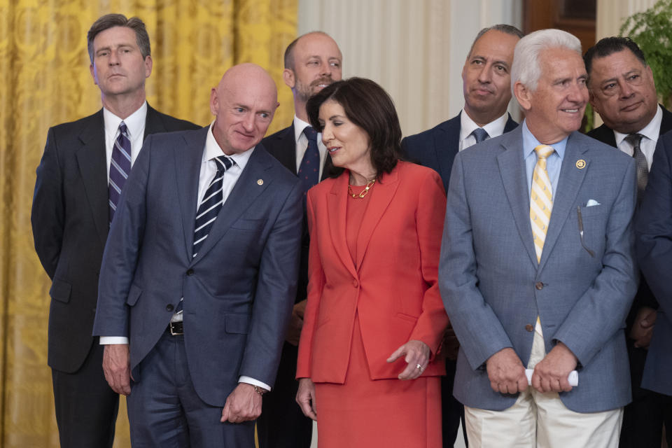 Sen. Mark Kelly, D-Ariz., front left, and New York Governor Kathy Hochul, center, attend an event in the East Room at the White House in Washington, Tuesday, June 4, 2024. President Joe Biden unveiled plans to enact immediate significant restrictions on migrants seeking asylum at the U.S.-Mexico border as the White House tries to neutralize immigration as a political liability ahead of the November elections. (AP Photo/Manuel Balce Ceneta)