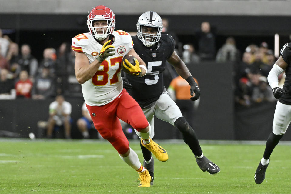 Kansas City Chiefs tight end Travis Kelce (87) runs in front of Las Vegas Raiders linebacker Divine Deablo (5) during the first half of an NFL football game, Sunday, Nov. 26, 2023, in Las Vegas. (AP Photo/David Becker)