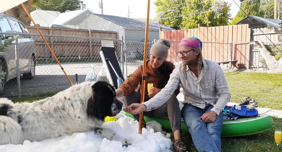 Maggie the dog, who lived in Utah, lies in the snow, flanked by her owners.