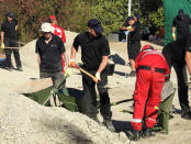 South Yorkshire police officers and members of the Greek rescue service (in red uniforms) investigate the ground while excavating a site during an investigation for Ben Needham, a 21-month-old British toddler who went missing in 1991, on the island of Kos, Greece, September 27, 2016. REUTERS/Vassilis Triandafyllou