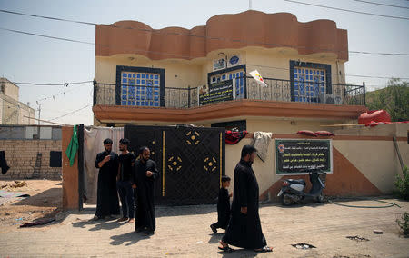 Relatives of Saad Khudair Abbas, who was killed with a group of youth by Islamic State militants at Kirkuk road, are seen outside a house in Kerbala, Iraq July 5, 2018. Picture taken July 5, 2018. REUTERS/Abdullah Dhiaa al-Deen