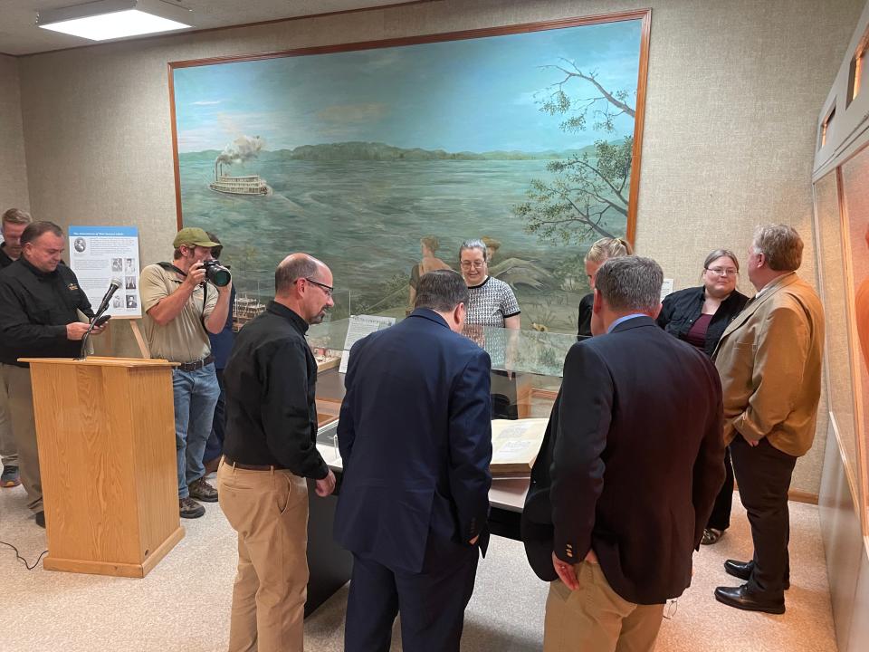 Secretary of State Jay Ashcroft and members of the Missouri Department of Natural Resources gather around Mark Twain's newly restored original manuscript of "The Adventures of Tom Sawyer" at the Mark Twain Birthplace State Historic Site in Florida, Mo. on Sept. 28, 2023.