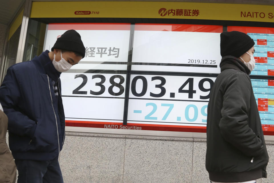 People walk by an electronic stock board of a securities firm in Tokyo, Wednesday, Dec. 25, 2019. Chinese and Japanese stocks declined Wednesday while most other Asian markets were closed for Christmas Day. (AP Photo/Koji Sasahara)
