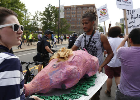 Demonstrators carry a papier mache pig with a blond wig as they join in a march by various groups, including "Black Lives Matter" and "Shut Down Trump and the RNC". REUTERS/Lucas Jackson