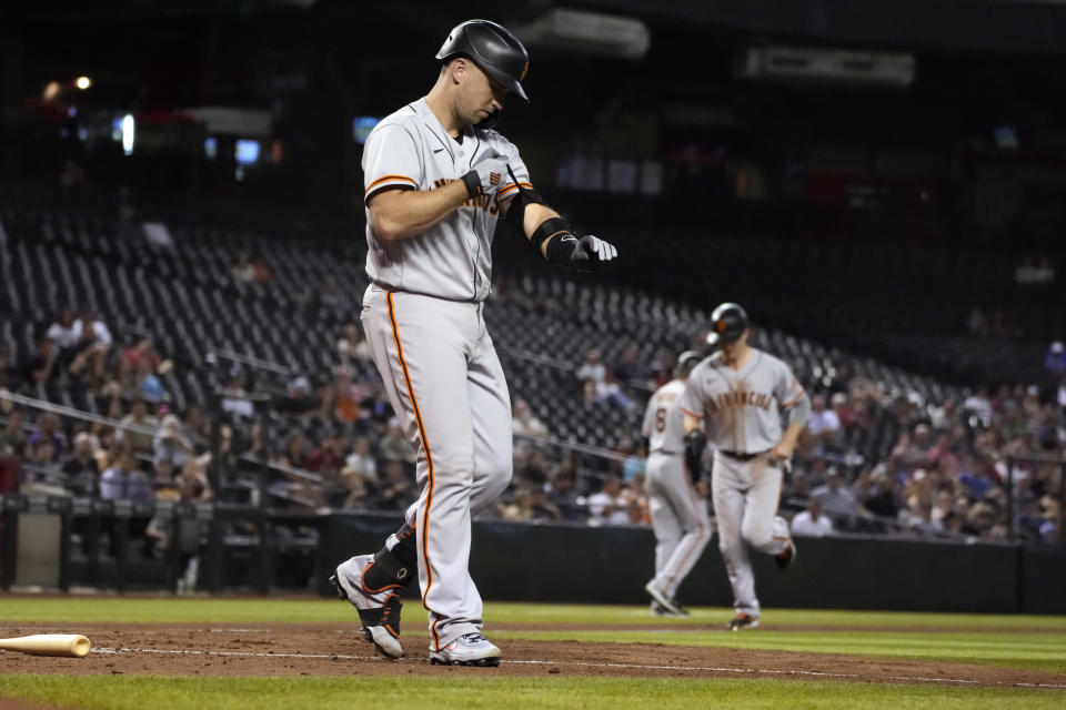 San Francisco Giants, Buster Posey, left, draws an RB-walk against the Arizona Diamondbacks in the fifth inning during a baseball game, Monday, Aug 2, 2021, in Phoenix. (AP Photo/Rick Scuteri)