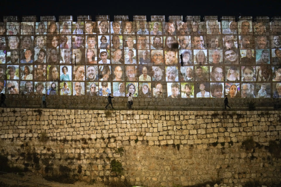 Fotografías de rehenes israelíes retenidos por Hamás, proyectadas en las paredes de la Ciudad Vieja de Jerusalén, el 6 de noviembre de 2023. (AP Foto/Leo Correa)