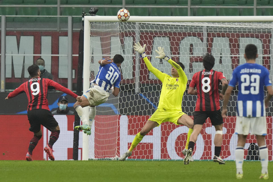 Porto's Evanilson, second left, heads the ball to hit the bar during the Champions League group B soccer match between AC Milan and Porto at the San Siro stadium in Milan, Italy, Wednesday, Nov. 3, 2021. (AP Photo/Luca Bruno)