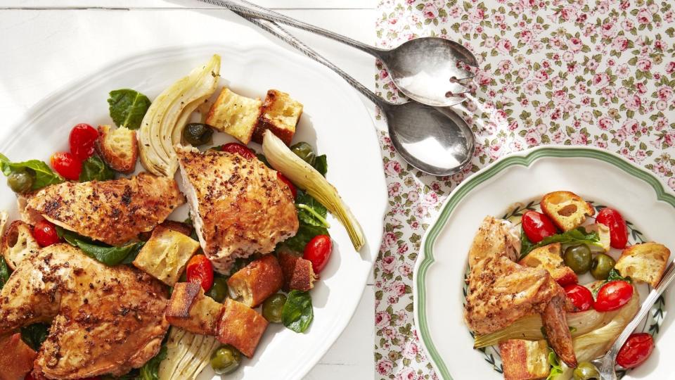 roasted chicken with fennel and tomatoes on a large serving plate with portions on two dinner plates next to it