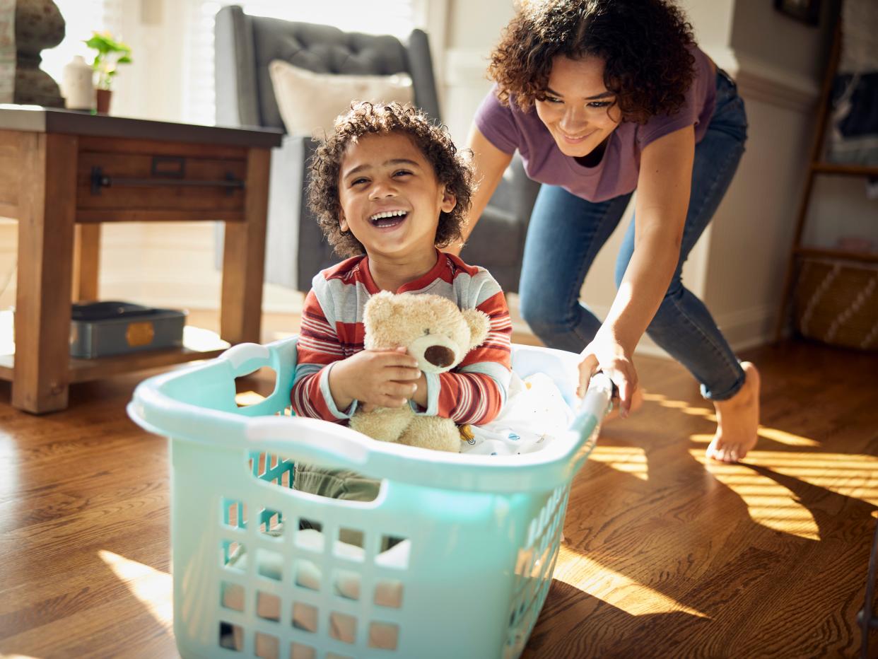 Older sister gives younger sibling a ride in the laundry basket