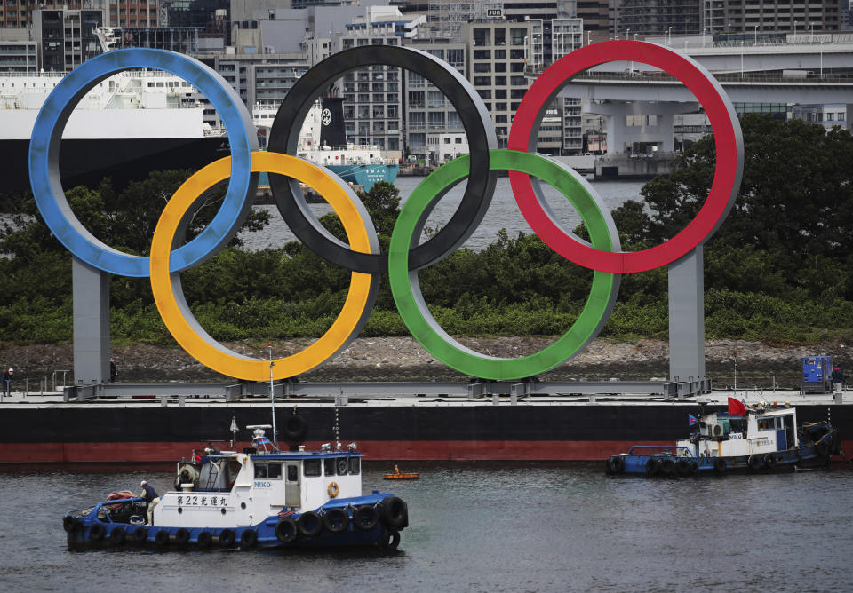 FILE - Boats prepare to tow giant Olympic rings as they are removed from the waterfront area at Odaiba Marine Park after 2020 Summer Olympics came to an end on Aug. 8 in Tokyo, Japan, Aug. 11, 2021. The Tokyo Olympic bid-rigging scandal widened Tuesday, Feb. 28, 2023, with Japanese advertising giant Dentsu and five other companies being charged by Tokyo district prosecutors. (Kim Kyung-Hoon/Pool Photo via AP, File)