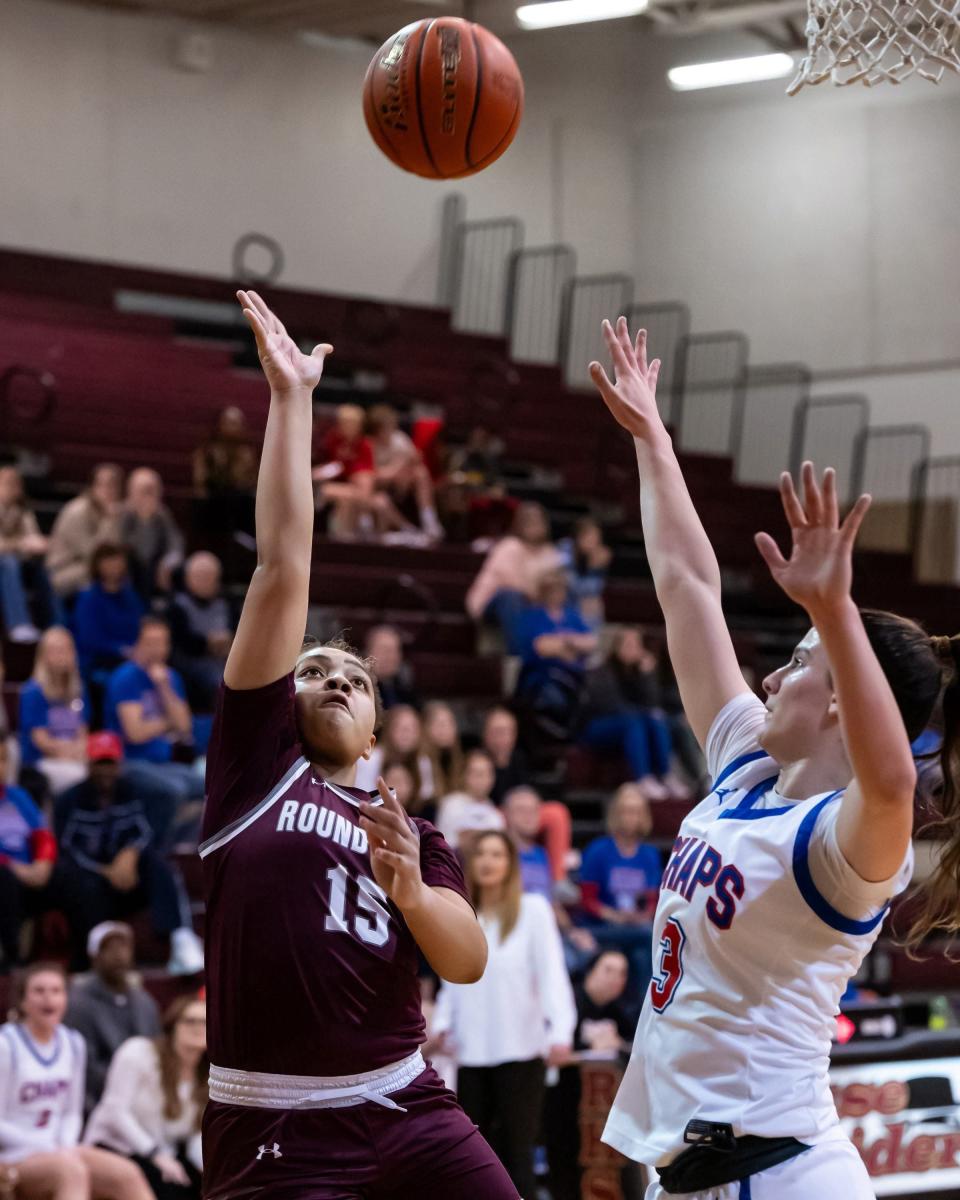Westlake's Gianna Angiolet, right, defends as Round Rock's AJ Burleson releases a shot during Monday night's bi-district playoff game at Rouse High School. The Chaps won 47-34 to advance to the Class 6A area round.