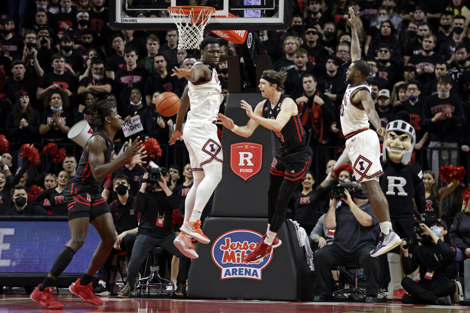 Rutgers guard Paul Mulcahy, second from right, passes the ball to Clifford Omoruyi around Illinois center Kofi Cockburn during the first half of an NCAA college basketball game Wednesday, Feb. 16, 2022, in Piscataway, N.J. (AP Photo/Adam Hunger)