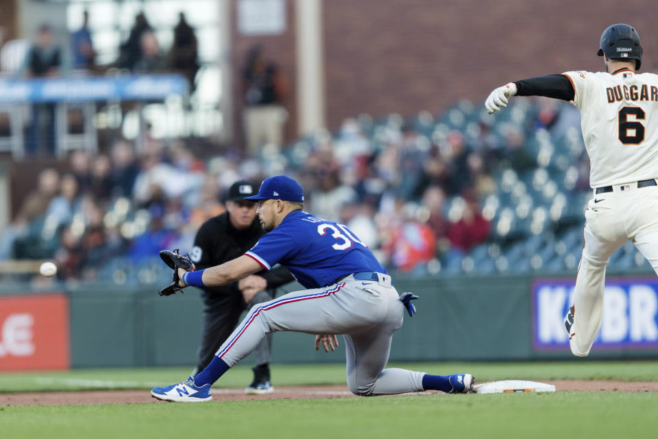 Texas Rangers first baseman Nate Lowe (30) makes the catch for an out against San Francisco Giants' Steven Duggar (6) during the third inning of a baseball game in San Francisco, Monday, May 10, 2021. (AP Photo/John Hefti)